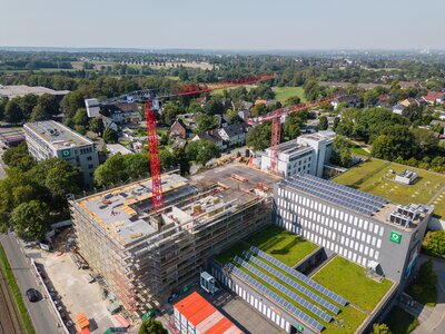 Blick auf den Rohbau für das neue DEICHMANN-Hauptgebäude – mit angrenzender Dachbegrünung und Photovoltaik-Systemen. Foto: Rüdiger Fessel, DEICHMANN SE